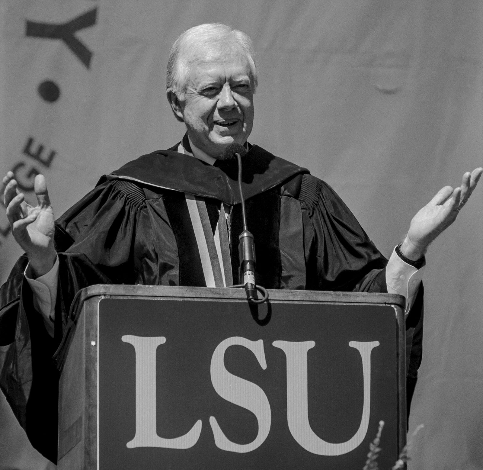 President Jimmy at LSU lectern speaking to graduates.