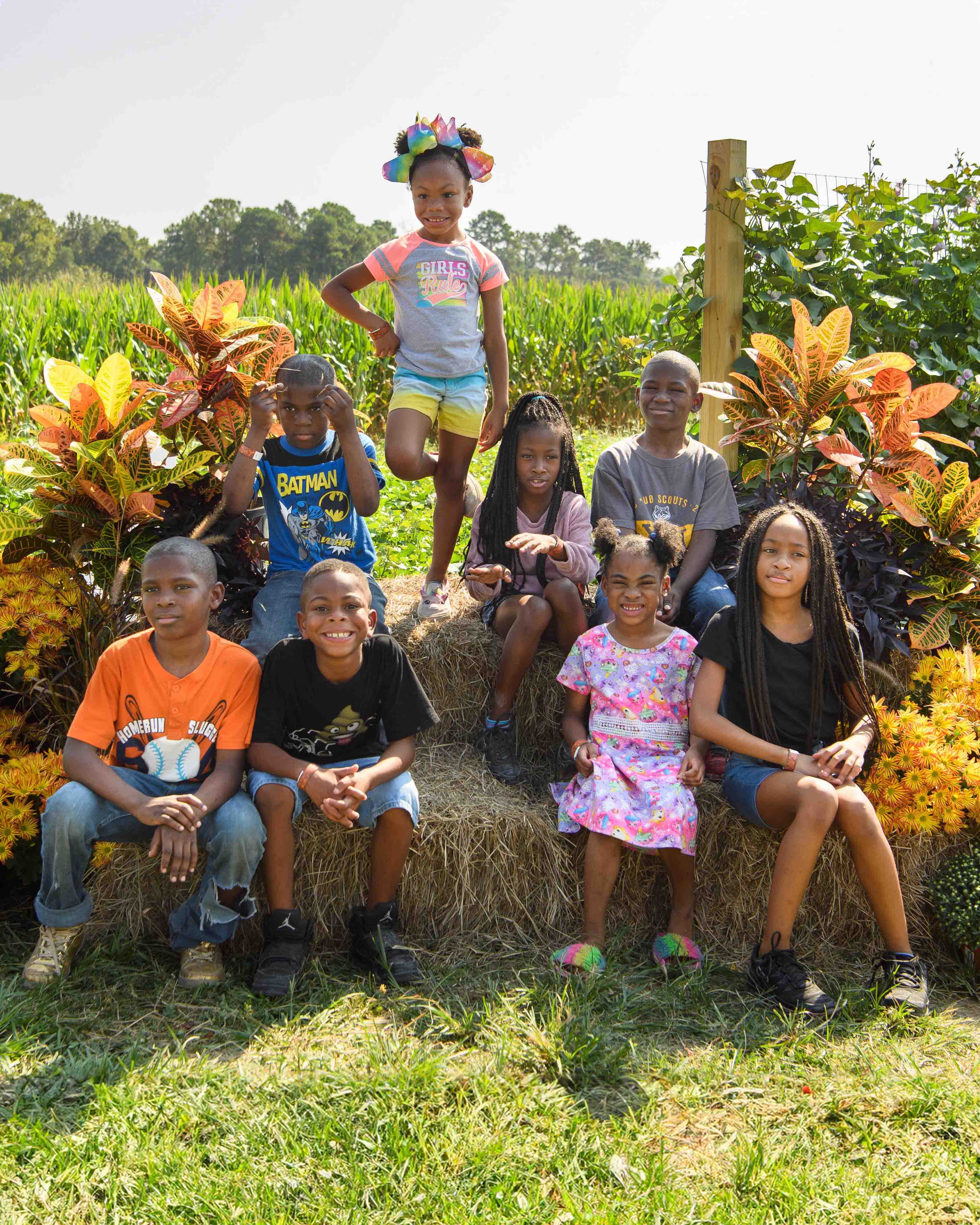 children sitting on hay bales