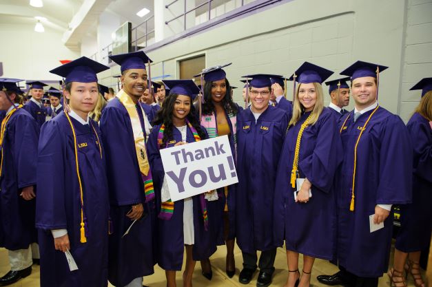 Graduates hold a Thank You poster at graduation ceremony