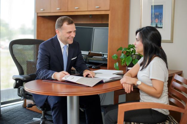Advisor speaks with student about resume in office. 