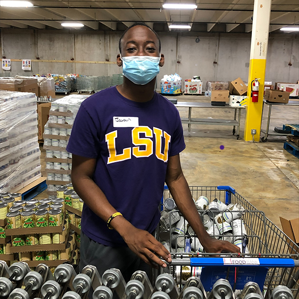 Man wearing LSU shirt volunteers at the Greater Baton Rouge Food Bank