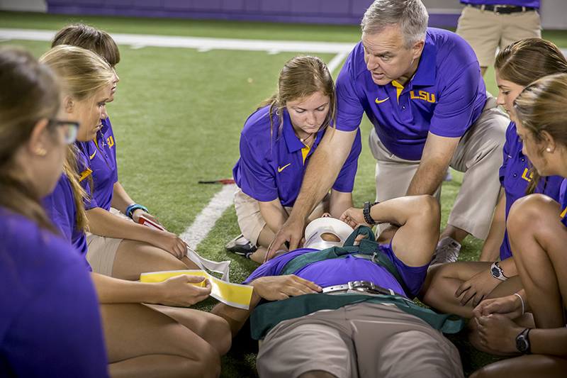 image of athletic training faculty and students on football practice field