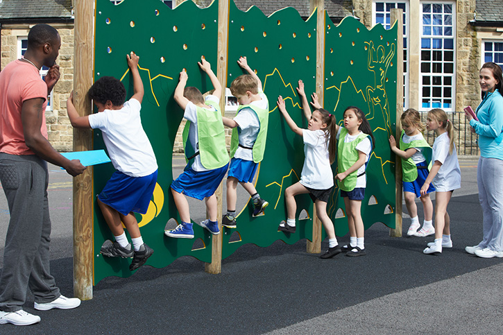 coach and students on climbing wall at PE