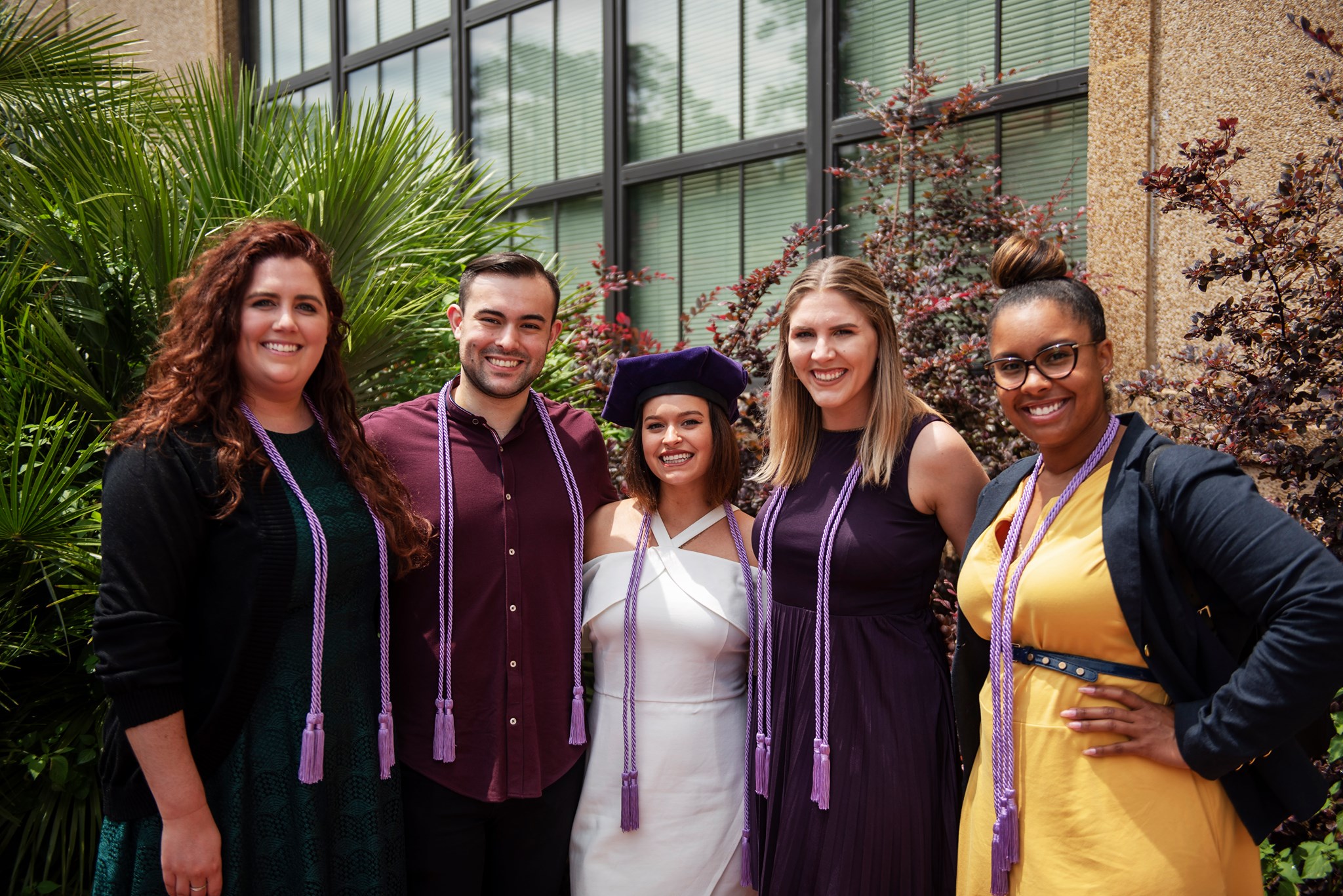 students with lavender graduation chords