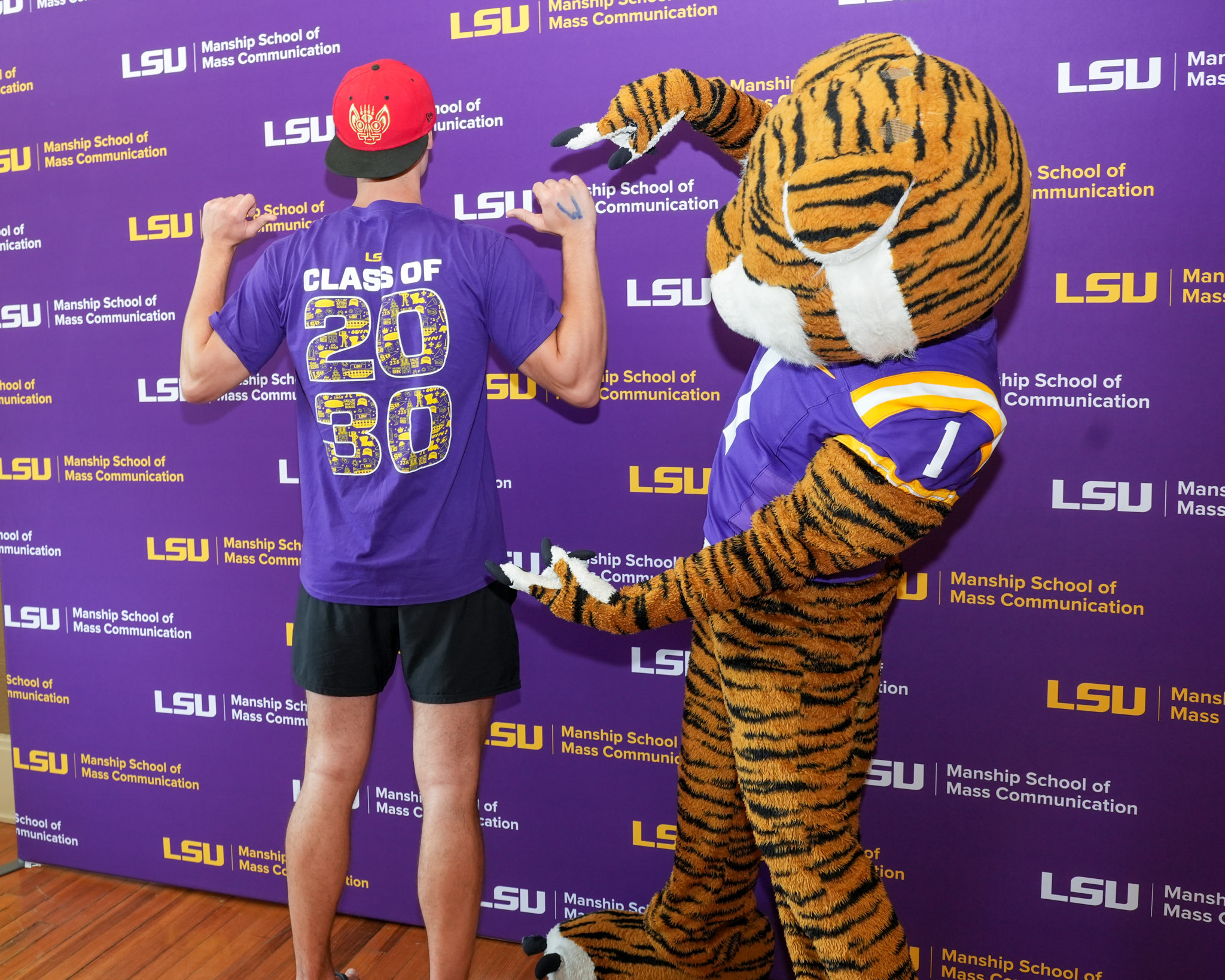 Mike the Tiger pointing at 2030 on a student shirt