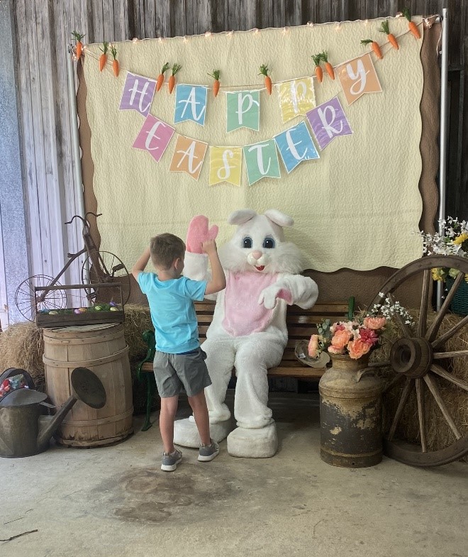 Little boy high fiving the Easter Bunny