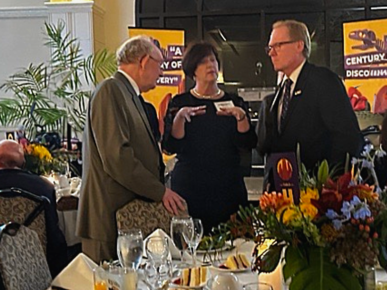 current and former administrators conversating at a table inside the gala event