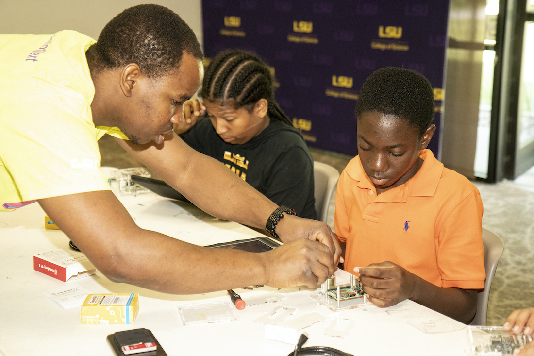 Our earth, our lab volunteer helping a participant put together his seismograph.