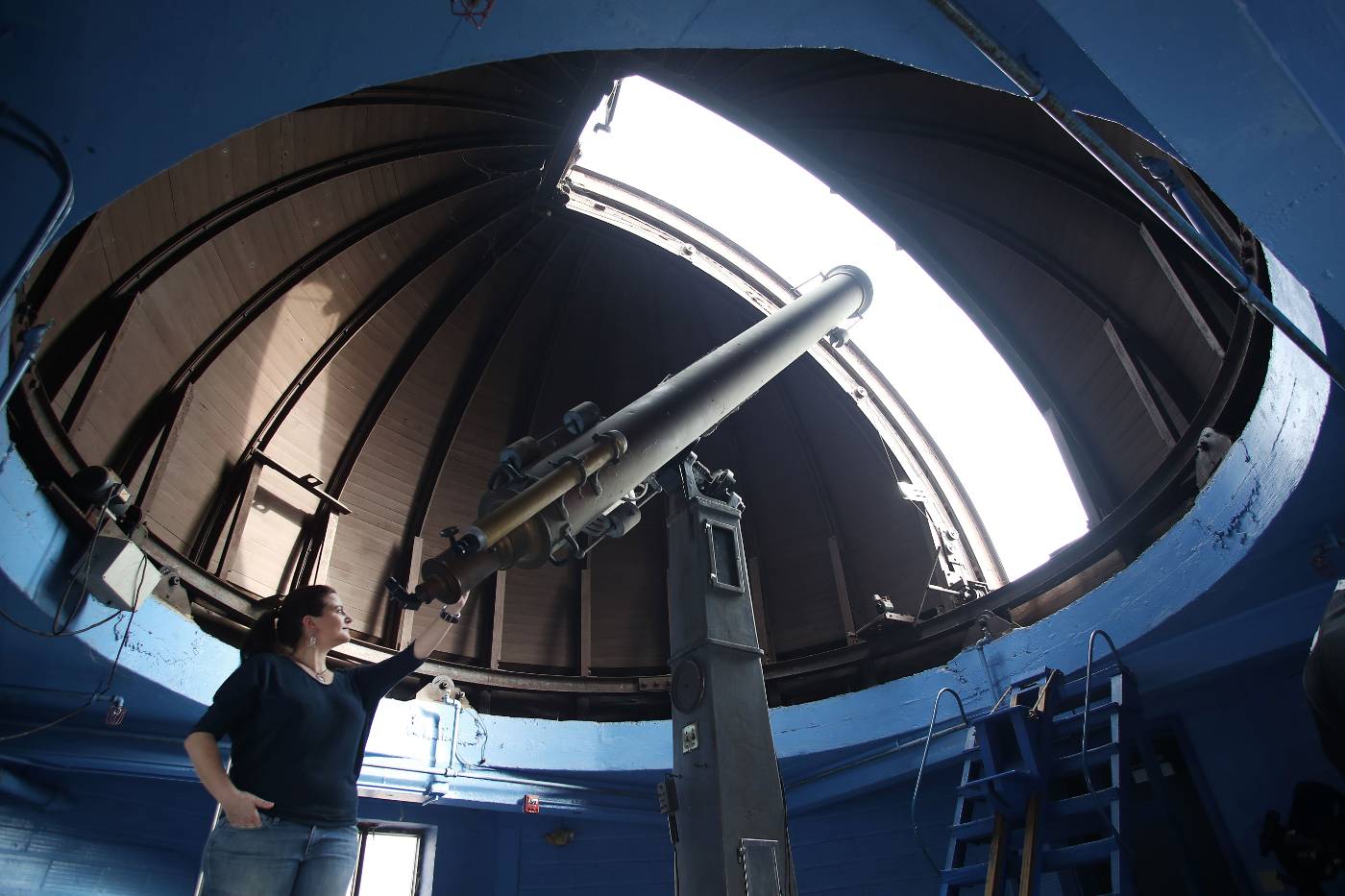 Astronomy faculty looking through observatory telescope