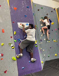 Shaping Futures participants climbing an indoor rock wall during the LSU program.